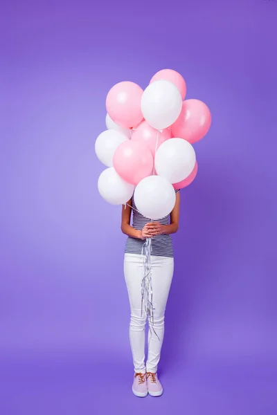 Vertical pleine longueur vue de la taille du corps de son beau-look slim fit mince fille à la mode tenant dans les mains tas de boules isolées sur violet vif brillant fond lumineux — Photo