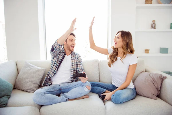 Dos persona agradable atractivo encantador alegre alegre alegre positivo chico dama sentada en diván palmadas que aplauden divertirse celebrando ganar en blanco claro estilo interior habitación interior — Foto de Stock