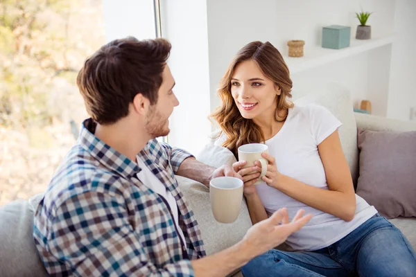 Nice-looking attractive lovely charming cute sweet cheerful guy lady sitting on couch sofa having fun time discussing news in light white style interior house indoors living room — Stock Photo, Image