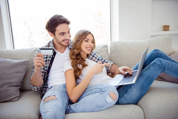 Portrait of her she his he two person nice attractive lovely cheerful cheery guy lady sitting oncozy  divan showing options buying goods on web site in light white style interior living room — Stock Photo, Image