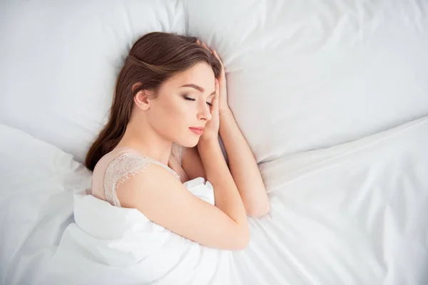 Topo acima de ângulo alto vista foto de encantadora senhora estudante serenidade toque bochechas cabeça fechar os olhos dia sonho cabelo penteado morena deitado cama têxtil roupa interior satisfeito feliz em luz apartamento — Fotografia de Stock