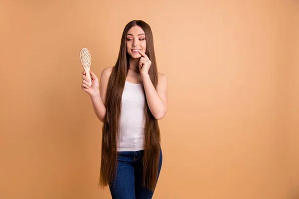 Close-up foto mooi haar She Lady arm hand aanbevelen nieuwe haren borstel zeer lang bruin haar grote voorwaarde krullen resultaat gebruik slijtage casual witte tank-top jeans geïsoleerd pastel beige achtergrond — Stockfoto