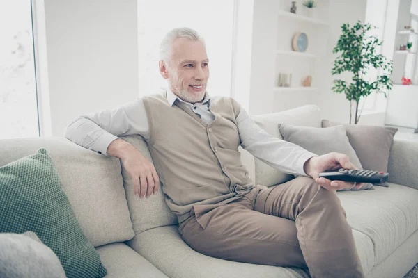 De cerca foto de perfil lateral increíble funky él su hombre de edad brazos manos consola cambio de canal de televisión medios de comunicación usar especificaciones camisa blanca pantalones chaleco sentarse comodidad brillante casa plana sala de estar en el interior —  Fotos de Stock