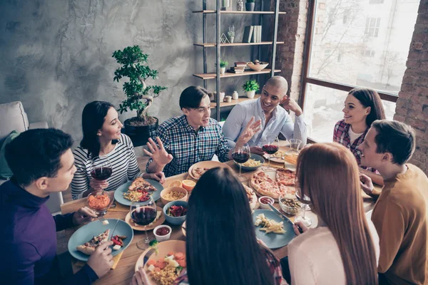 Close up photo communication best festive company social crowd event birthday members funky different race guys glass beverage sit table shirts formal-wear sweater pullover loft room indoors — Stock Photo, Image