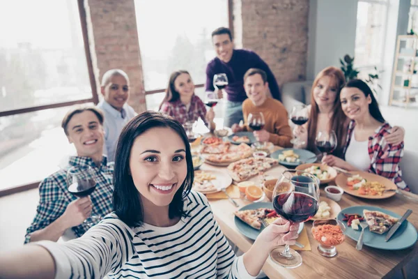 Primer plano foto comunicación empresa festiva agradable muchedumbre social evento miembros diferentes raza chicos levantar bebida hacer tomar selfies sentarse mesa camisas formal-desgaste suéter suéter loft habitación interior — Foto de Stock