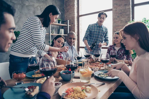 Close up Foto freundlich kommunizierende festliche Unternehmen Social Crowd Event behandelt Gastgeberin verschiedene Rennen Jungs gießen Gläser Getränke sitzen Tisch Hemden formell tragen Pullover Loft Zimmer drinnen — Stockfoto