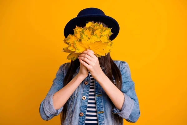 Πορτρέτο της αυτή όμορφη όμορφη ξανθιά κυρία που κρύβεται πίσω από τα πορτοκαλί φύλλα απομονώνονται πάνω από φωτεινό έντονο λαμπερό κίτρινο φόντο — Φωτογραφία Αρχείου