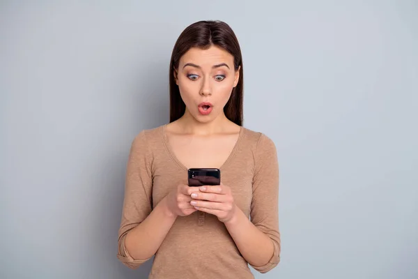 Retrato de impressionado linda senhora agradável jovem segurar mão tecnologias modernas olhar novidade reação maravilha desgaste inesperado roupas modernas isolado cinza prata fundo — Fotografia de Stock