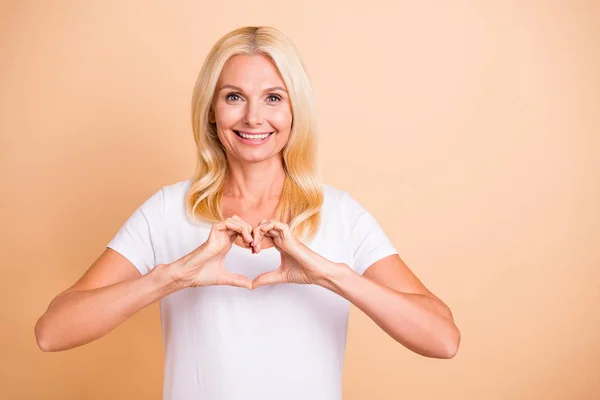 Close up foto di signora braccio dita fare cuore figura forma cardiologia concetto indossare bianco casual t-shirt isolato pastello sfondo beige — Foto Stock
