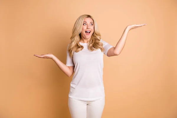 Portrét kouzelné roztomilostně veselé dámy doporučit propagace prodejní slevy nosit kalhoty kalhoty bílé módní izolované béžové pozadí — Stock fotografie