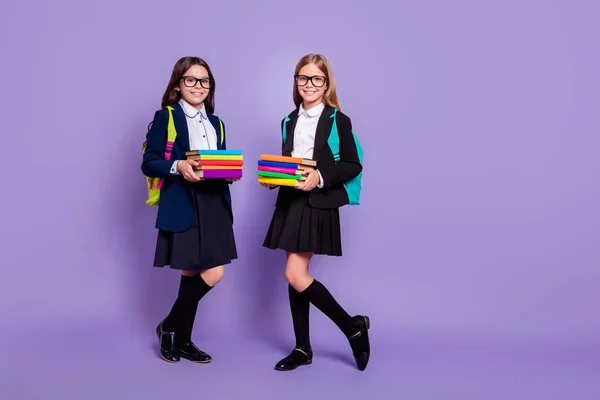 Foto de comprimento total de crianças segurar mão literatura desgaste óculos óculos saco mochila mochila saia meias longas isoladas sobre fundo violeta — Fotografia de Stock