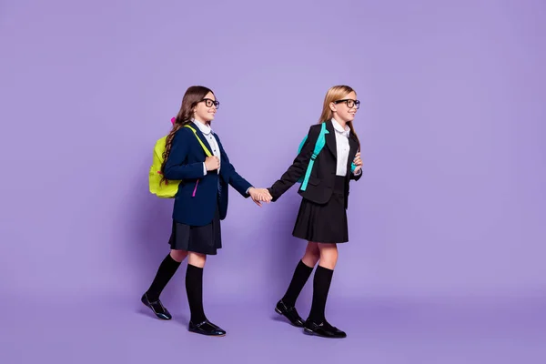 Foto de corpo inteiro de crianças bonitos rota cursos escolares usar meias longas saia óculos óculos isolados sobre violeta roxo fundo — Fotografia de Stock