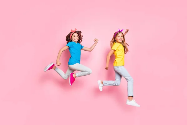 Profil pleine grandeur photo de côté des enfants portent pantalon pantalons bandeaux longue coiffure ondulée lever les mains poings concours joueurs isolés sur fond rose — Photo