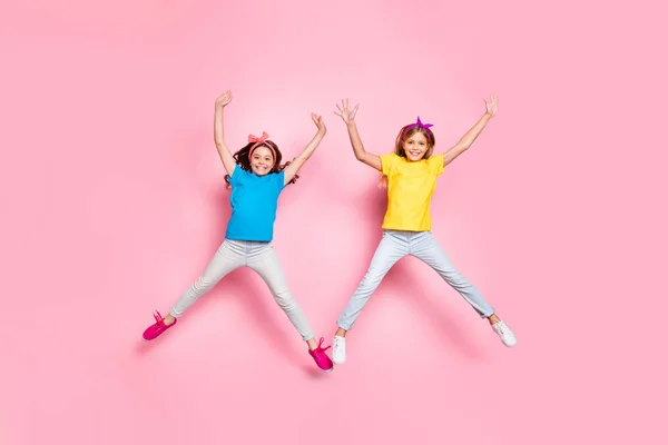 Photo pleine grandeur des enfants gais élégants se déplaçant lever les mains bras porter pantalon pantalon isolé sur fond rose — Photo