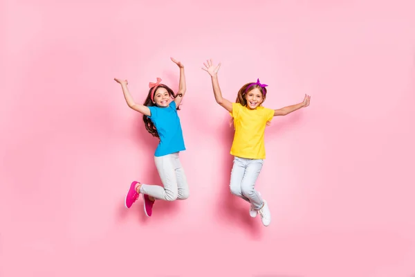 Ful längd foto av söta schoolchlidren har helger höja händerna bär pannband t-shirt byxor byxor isolerade över rosa bakgrund — Stockfoto