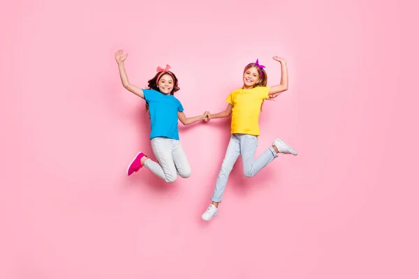 Foto em tamanho completo de crianças adoráveis levantar as mãos tem tempo livre desgaste calças de t-shirt isoladas sobre fundo rosa — Fotografia de Stock