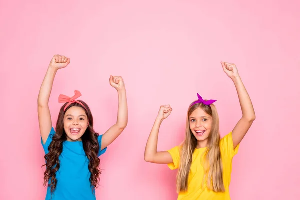 Портрет двох привабливих привабливих чарівних милих веселих веселих щасливих позитивних попередніх дівчаток, які радіють підняттю рук ізольовані на рожевому пастельному фоні — стокове фото