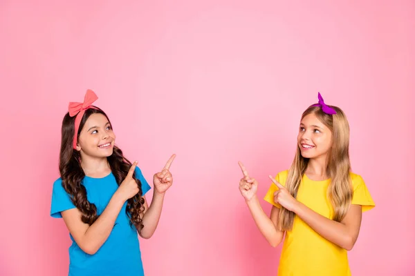 Porträtt av två snygga attraktiva charmiga söta vackra säker innehåll glada glada pre-teen flickor som visar befordran annons AD isolerad på rosa pastell bakgrund — Stockfoto