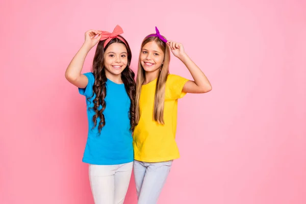 Portret van twee mooi uitziende aantrekkelijke zoete Winsome charmante schattige mooie vriendelijke vrolijke vrolijke Pre-Teen meisjes samen Fixing bogen plezier geïsoleerd op roze pastel achtergrond — Stockfoto