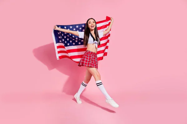 全身配置文件照片的漂亮女士携带美国国旗大学大学英国沼泽穿白色上衣短格子裙孤立的粉红色背景 — 图库照片