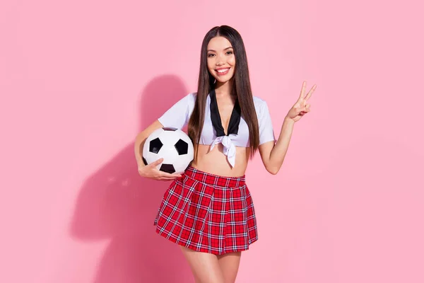 Foto di allegra signora cheerleader v-segno simbolo capo comitato scolastico calcio palla indossare rosso gonna corta bianco top isolato rosa sfondo — Foto Stock