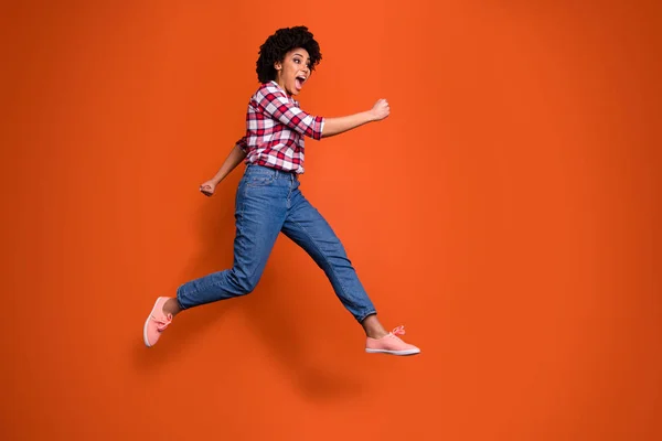 Full Body Side Foto van opgewonden Jumping High Lady schreeuwen luide verkoop korting winkelen slijtage casual kleding outfit geïsoleerd oranje achtergrond — Stockfoto