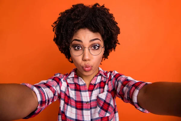 Close up foto de senhora engraçada fazendo selfies humor brincalhão enviar ar beijo desgaste especificações casuais xadrez camisa isolado laranja brilhante fundo — Fotografia de Stock