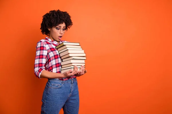 Cerrar foto de perfil lateral hermosa ella su modelo señora oh no expresión boca abierta abrazos manos muchos libros examen estupor desgaste casual cuadros camisa aislado brillante fondo naranja —  Fotos de Stock