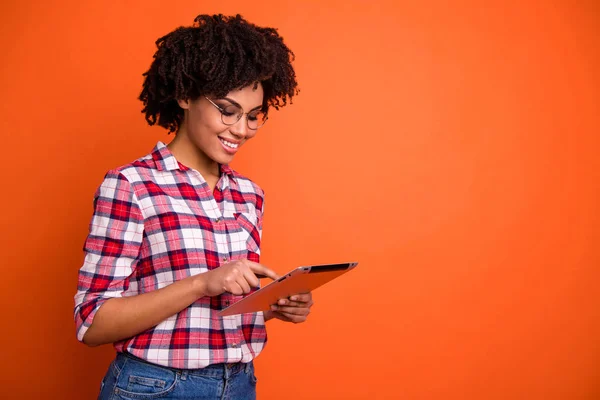 Retrato de bonito bonito conteúdo alegre alegre inteligente inteligente inteligente de cabelos ondulados senhora nerd vestindo óculos de camisa verificados usando digital e-book tempo livre isolado sobre brilhante brilho vívido laranja — Fotografia de Stock