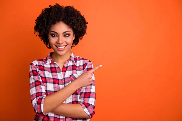Close-up portrait of her she nice attractive cheerful cheery confident wavy-haired lady wearing checked shirt pointing aside tips feedback advert isolated on bright vivid shine orange background — Stock Photo, Image