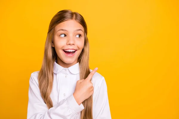 Närbild porträtt av henne hon snygg attraktiva vackra kreativa geni glad glada rakhåriga pre-Teen Girl pekar åt sidan annonsen isolerad på ljusa levande glans gul bakgrund — Stockfoto