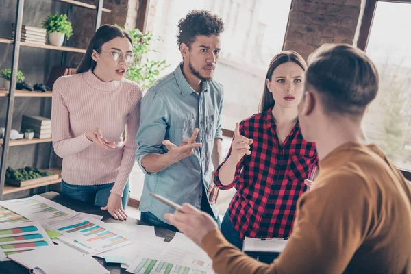 Portrett av irriterte, unge, årtusener av gester - hånd-tale sier sinne, sint, stilig, trendy skjorte, rutete, blå, rød genser, bord, industrielt loftinteriør – stockfoto