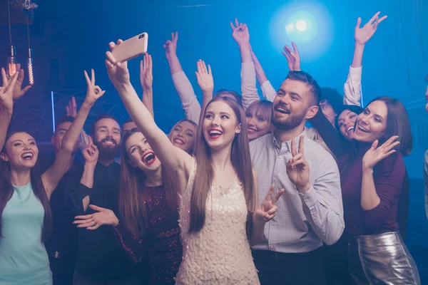 Portret van mooie chique glamoureuze aantrekkelijke modieuze stijlvolle prachtige vrolijke positieve blij grappige dames en jongens plezier maken selfie tonen v-teken symbool op moderne mistlichten nachtclub — Stockfoto