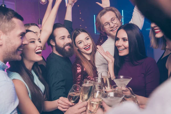 Portrait of nice charming glamorous fascinating attractive cheerful cheery glad ladies and guys having fun clinking wineglasses sparkles birthday tradition surprise at fogged lights nightclub