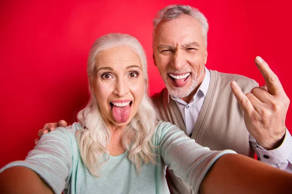 Close up photo beautiful she her he he his aged white hair guy lady partners couple make take selfies funky tongue out mouth rock concert wear sweater shirt waistcoat isolated red burgundy background —  Fotos de Stock