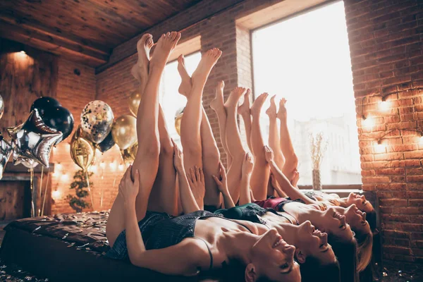 Νίκαια ελκυστικές συναρπαστικές θηλυκές γυναίκες που βρίσκονται στο κρεβάτι διέσχισε καλά-καλλωπισμένο πόδια εορταστική εορταστική εκδήλωση Spa προετοιμασία αγγίζοντας μαλακό λείο αγνό δέρμα σε σοφίτα βιομηχανικό στυλ εσωτερικό δωμάτιο — Φωτογραφία Αρχείου