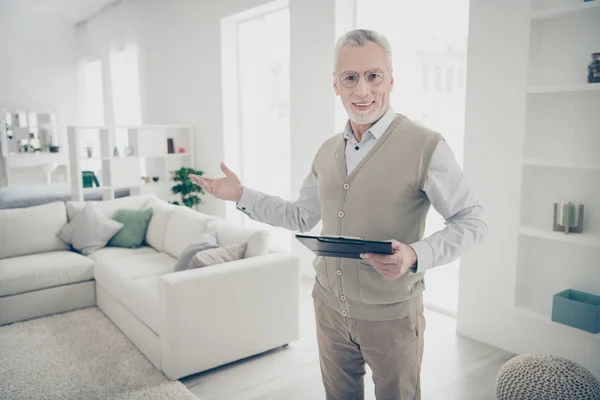 Close up photo amazing he him his aged man arm hand show clean space skilled specialist hold pen notice contract details wear white shirt waistcoat pants comfy bright flat house living room indoors