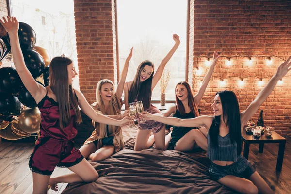 Close up photo five beautiful event bachelor she her ladies hands arms raised up glasses festive golden beverage short nightie sit sheets clink tell talk toasts sleep costumes girls night room indoors — Stock Photo, Image