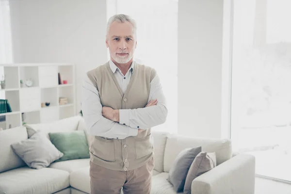 Close up foto incrível manager he him his aged man arms crossed bossy chief look self-confident wear white shirt waistcoat pants stand near cozy comfort divan bright flat house living room indoors — Fotografia de Stock