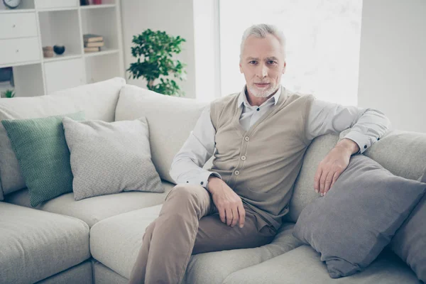 Close up foto incrível ele ele seu homem velho inspiração calma calma bondoso fácil de ir olhar sério desgaste camisa branca calças de colete sentar conforto divã casa plana brilhante sala de estar dentro de casa — Fotografia de Stock