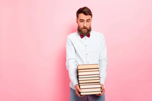 Foto von weinenden frustrierten Kerl mit schwerem Stapel Bücher in den Händen isoliert Pastell Hintergrund — Stockfoto