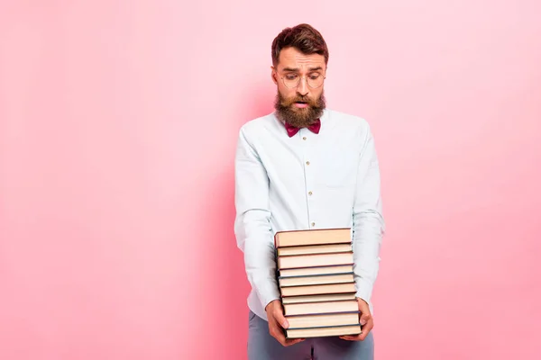 Foto de choro cara frustrado segurando pilha pesada de livros em mãos isolado fundo pastel — Fotografia de Stock