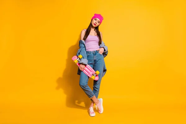 Full length dimensioni del corpo foto abbastanza bella lei la sua signora incredibile bello sguardo mano braccio skate board adorare appassionato di pericoloso sport usura casual jeans denim giacca scarpe rosa cappello isolato giallo sfondo — Foto Stock