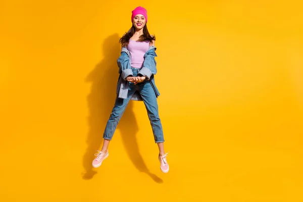 Full length corpo formato foto bello incredibile lei la sua signora mani braccia insieme saltare alto sporty day off umore cool look usura casual jeans jeans giacca scarpe rosa cappello isolato giallo brillante sfondo — Foto Stock