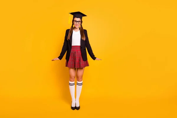 Longitud completa tamaño del cuerpo ver foto encantadora gente joven posando gafas gafas coleta cola de caballo rodilla-calcetines falda roja grado cuadros cuadros larga chaqueta negra aislado fondo amarillo —  Fotos de Stock