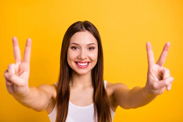 Close up photo beautiful amazing she her lady positive funny good job hands v-sign symbol say hello friends relatives parents wear casual white tank-top isolated bright yellow background — стоковое фото