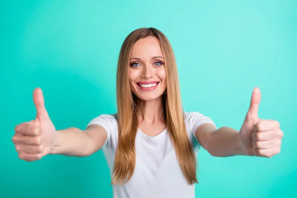 Retrato de linda dama mostrando promo sonriendo usando camiseta blanca aislada sobre fondo azul turquesa — Foto de Stock