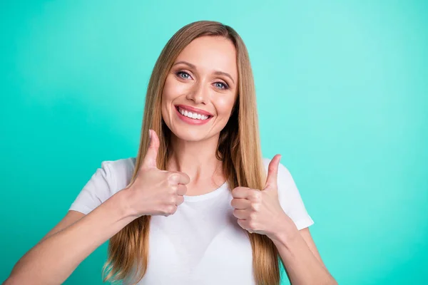 Close-up foto van Charming Lady met toothy glimlachend tonen duimen omhoog dragen wit t-shirt geïsoleerd over Teal Turquoise achtergrond — Stockfoto