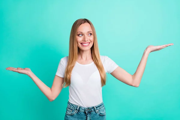 Portret van charmante persoon holding haar palmen met advertenties dragen wit t-shirt jeans geïsoleerd over Teal Turquoise achtergrond — Stockfoto