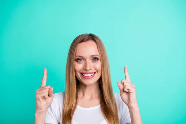 Close-up foto van charmante promotor wijzende vinger omhoog glimlachend dragen wit t-shirt geïsoleerd over Teal Turquoise achtergrond — Stockfoto